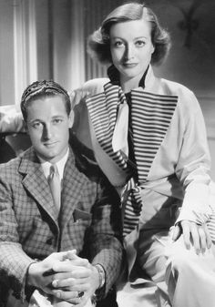 an old black and white photo of a man and woman sitting next to each other