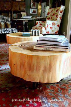 two tables with books stacked on top of each other in front of a living room couch