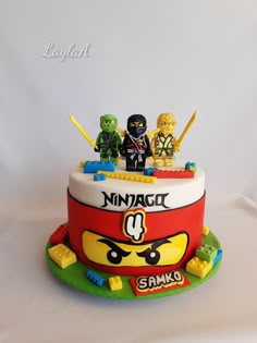 a cake with legos sitting on top of it and the words ninjacli spelled out