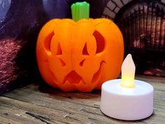 a carved pumpkin sitting next to a lit candle