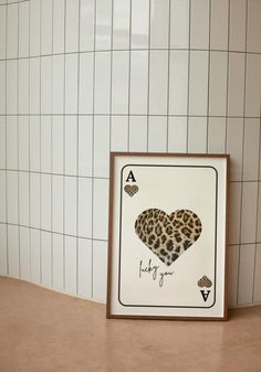 a card with a heart on it sitting next to a tile wall in a bathroom