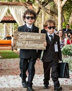 two young boys in suits and sunglasses holding a sign that says segurrancas dos alunas