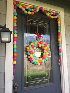 a front door with a wreath made out of balloons on it and a lantern hanging from the side