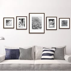 a living room filled with lots of furniture and pictures on the wall above it's couch