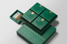 four matchboxes are stacked on top of each other with gold trimmings