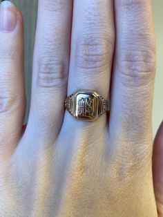 a woman's hand with a gold ring on top of her finger and the word love written in it