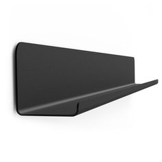 a black wall mounted shelf on the side of a white wall with an angled corner