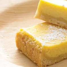 two pieces of yellow cake sitting on top of a wooden table next to each other