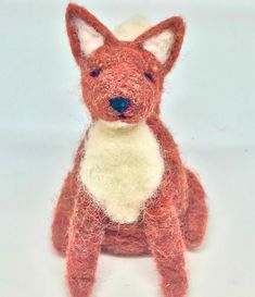 an orange and white stuffed animal sitting on top of a table