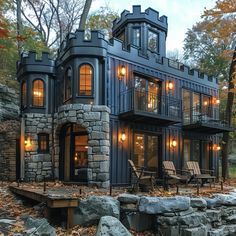 a black house surrounded by trees and rocks