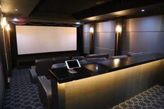 an empty theater room with chairs and a projector screen