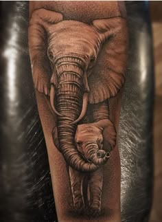 an elephant and its baby tattoo on the arm