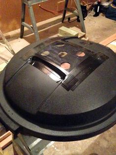 an old black record player sitting on top of a wooden table in a room with tools