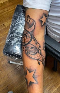 a tattoo with musical notes and stars on it