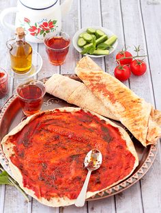 a plate full of food on a table with tea, sauces and other foods