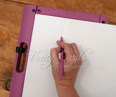 a person is writing on a piece of paper with a pen in their left hand