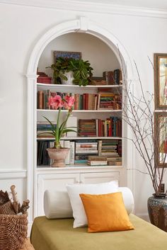 a bed sitting under a book shelf filled with books