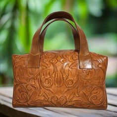 This rustic tooled leather purse, with its stunning chiseled design, is the ideal accessory to add a touch of vintage elegance to your daily wardrobe. Expertly handmade by skilled artisans, it's the perfect size to carry all your essentials and is sure to make a distinctive statement that sets you apart from the crowd. The perfect choice as a gift for her 🪷Measures : height:17 cm.  6 1/2 inches width :30cm.  12 inches base:14 cm.  5 1/2 inches straps: 15cm    6 inches interior: suede leather zi Womens Leather Bag, Custom Leather Work, Tooled Leather Bag, Handmade Handbag, Tooled Leather Purse, Leather Artisan, Cowgirl Western, Brown Bag, Vintage Elegance