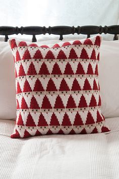 a red and white pillow sitting on top of a bed