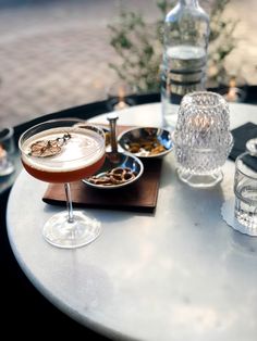 a table topped with glasses filled with different types of drinks and food on top of it