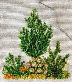 a potted plant with many different colored flowers on it's side, in front of a beige background