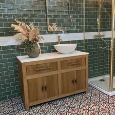 a bathroom with two sinks and a stand up shower in the corner next to a tiled wall