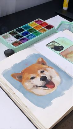 an open book with a dog's face on it and watercolors in the background