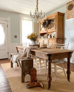 a dining room table with chairs and a chandelier hanging from the ceiling above it