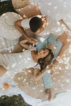 two women and a man sitting on the ground