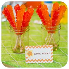 two mason jars filled with candies on top of a table