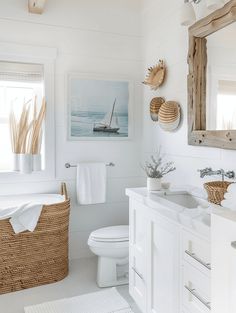 a bathroom with white walls and flooring, including a wicker basket on the sink