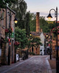 a cobblestone street lined with old brick buildings and lanterns hanging from the ceiling