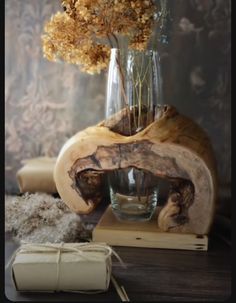 a vase filled with flowers sitting on top of a wooden table next to a book