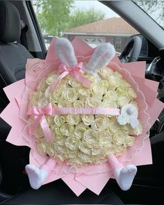 a bouquet of roses in the back seat of a car with bunny ears on it