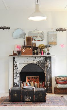 a living room with a fire place and an old trunk