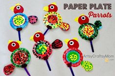 paper plate parrots made out of construction paper and plastic straws are on top of each other