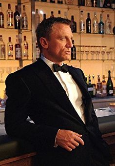 a man in a tuxedo sitting at a bar