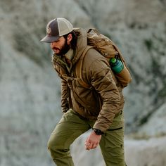 a man with a backpack is walking on rocks