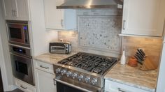 a stove top oven sitting inside of a kitchen next to a microwave and toaster oven