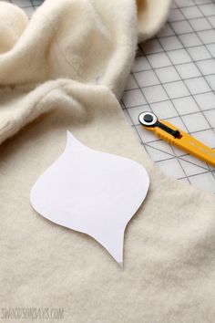 a pair of scissors sitting on top of a piece of paper next to some fabric