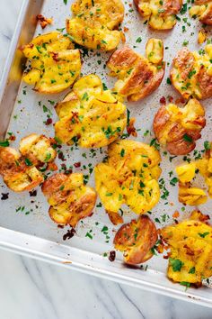 baked tomatoes with cheese and herbs on a baking sheet, ready to be cooked in the oven