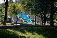 an empty park with several slides in the distance