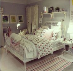 a white bed sitting in a bedroom on top of a floor next to a rug