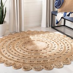 a large round rug on the floor in front of a chair and potted plant