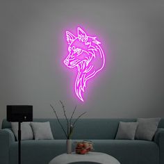 a living room with a couch and a neon pink wall decal on the wall