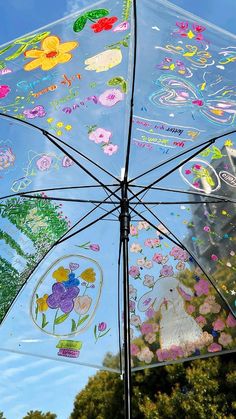 an umbrella with many stickers on it in front of trees and blue sky background