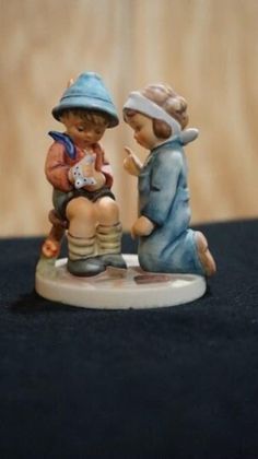 two figurines sitting on top of a table