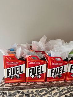 four red boxes filled with fuel sitting on top of a table