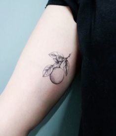 a woman's arm with a small apple tattoo on the left side of her arm