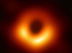 a black hole is shown in the middle of an orange and red light that appears to be dark